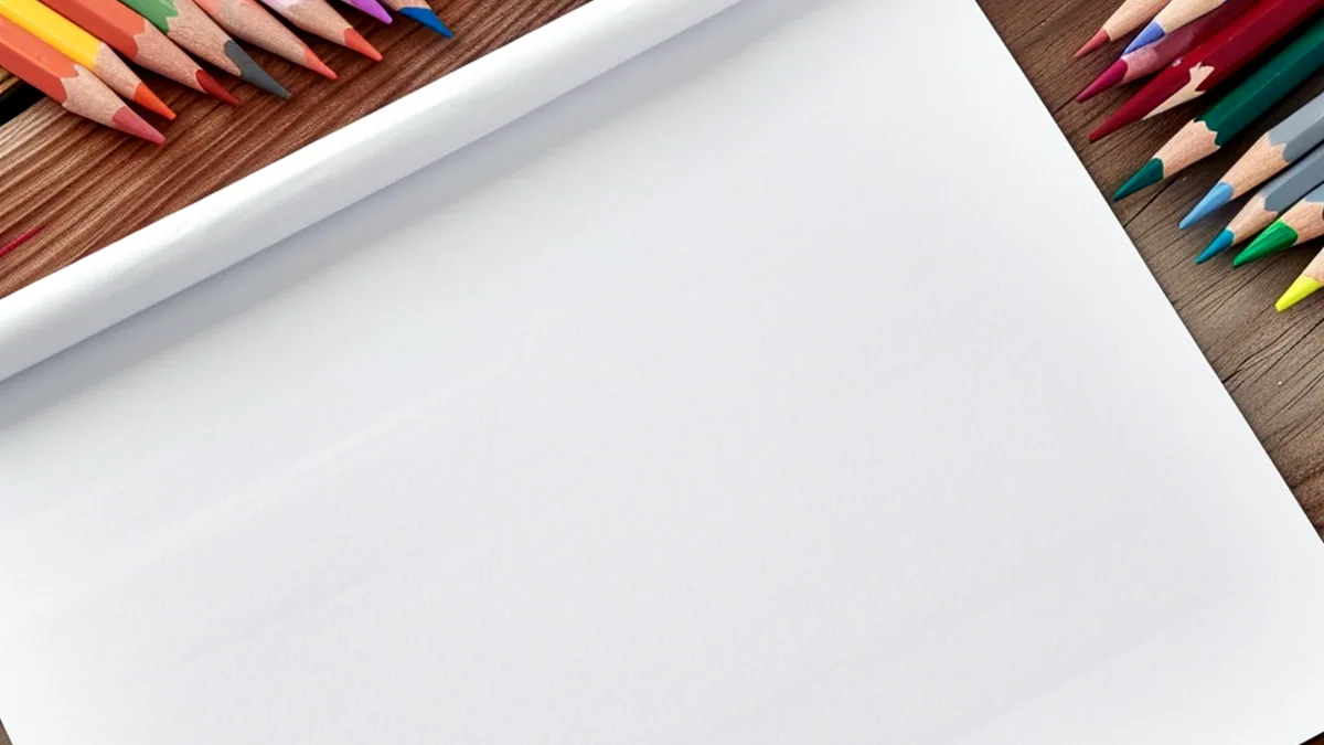 Lápices de colores sobre un papel en blanco sobre una mesa.
